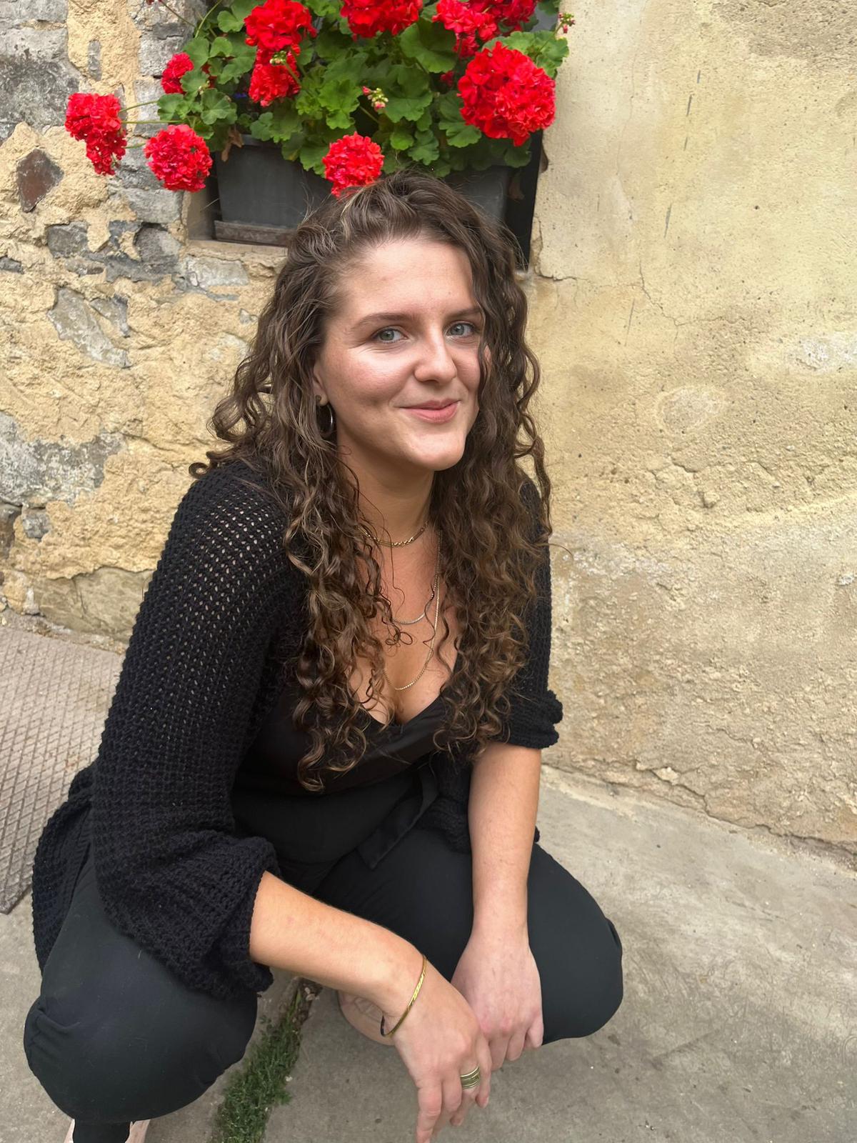 Barbora Malá s jemným úsměvem u béžové zdi